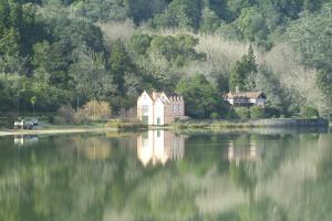 a house sitting on the shore of a lake at Casa Dos Barcos Furnas in Furnas