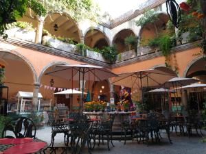 an outdoor patio with tables and chairs with umbrellas at Casa Relox 23 in San Miguel de Allende