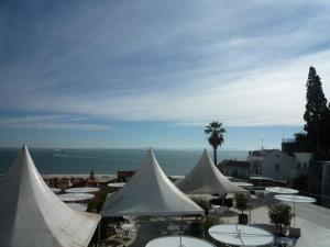 a group of white tents with the ocean in the background at Casas do Castelo in Lisbon