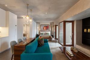 a living room with a blue couch and a bed at S.Bento Residences in Porto