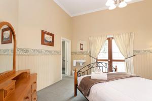 a bedroom with a bed and a dresser and a window at Historic Shipping Office - Akaroa in Akaroa