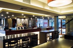 a restaurant with a bar with stools and a bar sidx sidx sidx at The Astor Hotel Motel in Goulburn