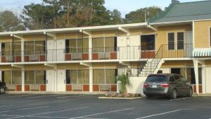 a car parked in a parking lot in front of a building at Best Rest Inn - Jacksonville in Jacksonville