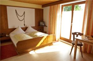 a bed in a room with a large window at Hotel Restaurant Kröll in Reutte