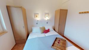 ペルツァーハケンにあるFeriendorf Südstrand Haus 44の小さなベッドルーム(ベッド1台、木製キャビネット付)