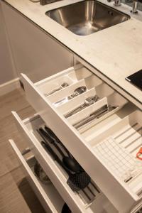 an open drawer in a kitchen with a sink at Pupin Palace Apartments in Novi Sad