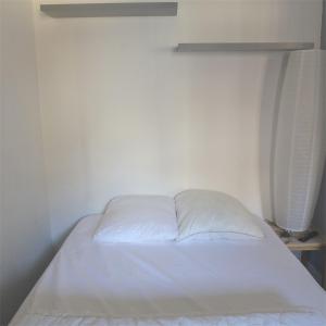 Cama blanca en habitación con pared blanca en Réf 539, Seignosse Océan, Appartement à 150m de la plage, proche commerces, 4 personnes, en Seignosse