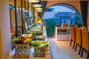 a buffet line with plates of food in a restaurant at Ritzy Boutique Hotel Da Nang Beach in Da Nang