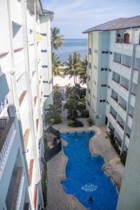 an aerial view of a swimming pool between two buildings at Stylish Beachfront Apartment Mombasa King Sized bed in Mombasa