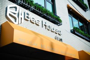 Bee House by Cosmos Creation - Taipei Main Station في تايبيه: علامة لبيت ستيك على جانب المبنى