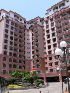 a large apartment building with a fountain in front of it at Dorcas Service Apartment - Marina Court in Kota Kinabalu