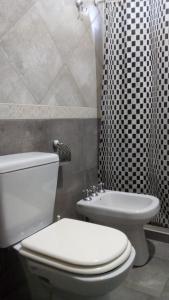 a bathroom with a white toilet and a shower at Dimensión moonlight in La Falda +27 photos