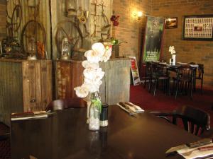 a table with a vase with white flowers on it at Cattleman's Rest Motor Inn in Charters Towers