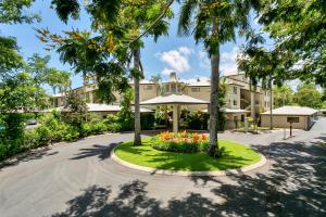 an empty road in front of a building with trees at Trinity Links Resort in Cairns