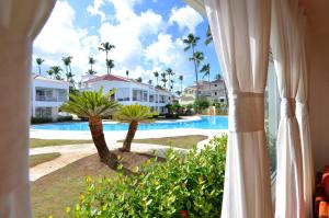Blick auf den Pool aus dem Fenster eines Resorts in der Unterkunft La Flor del Caribe Beach & SPA in Punta Cana