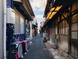 een smal steegje met gebouwen en een straat met bij Gunjonoma Yadokari in Okayama