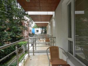 a balcony with chairs and tables on a building at Brunton Heights Executive Suites in Bangalore