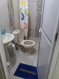 La salle de bains est pourvue de toilettes blanches et d'un lavabo. dans l'établissement Hotel Don Toño Tolú, à Tolú