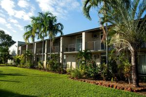 a building with palm trees in front of it at Walkabout Lodge in Nhulunbuy