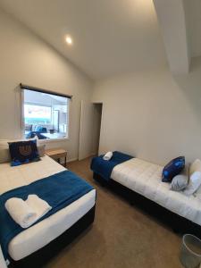een slaapkamer met 2 bedden en een raam bij U Suites Kilbirnie in Wellington