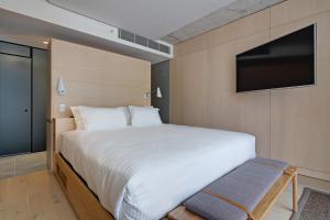 a bedroom with a large bed and a flat screen tv at Zara Tower – Luxury Suites and Apartments in Sydney