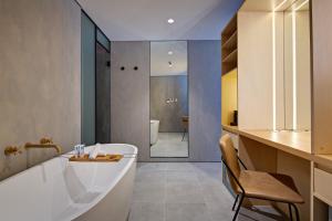 a bathroom with a tub and a chair in it at Zara Tower – Luxury Suites and Apartments in Sydney
