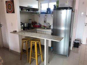 una cucina con bancone e frigorifero di Apple Flat 501 a Natal