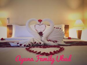 two swans making a heart shape on a bed at Ayuna Family Ubud in Ubud