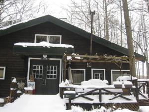 una baita di tronchi con neve sulla parte anteriore di Lodge Stack Point a Narusawa