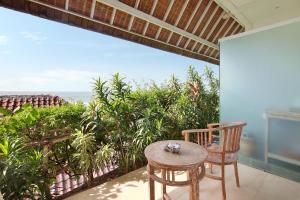 una mesa y una silla en un balcón con vistas al océano en Kerang Bingin Beach Villa, en Uluwatu