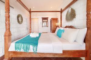 1 dormitorio con 1 cama grande con almohadas blancas y azules en Kerang Bingin Beach Villa, en Uluwatu
