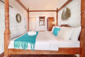 a bedroom with a large bed with white and blue pillows at Kerang Bingin Beach Villa in Uluwatu
