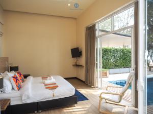 1 dormitorio con 1 cama y puerta corredera de cristal en Sea and Sea Villa Sangaroon en Ban Nam Tok