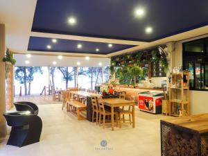 ein Restaurant mit Tischen und Stühlen in einem Zimmer in der Unterkunft Sea and Sea Villa Sangaroon in Ban Nam Tok
