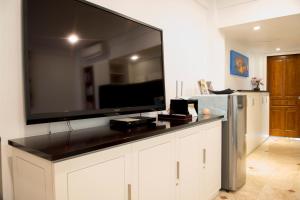 a living room with a large flat screen tv on a wall at Sofi Apartment at Jayakarta Residence in Legian