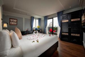 ein Schlafzimmer mit einem großen weißen Bett mit Blumen darauf in der Unterkunft Hanoi Media Hotel & Spa in Hanoi