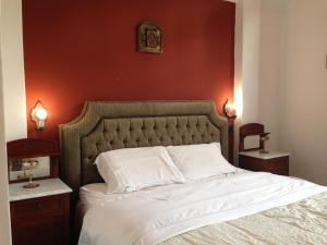 1 dormitorio con 1 cama grande y pared roja en Casablanca, en Lima