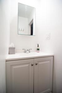 a bathroom with a white sink and a mirror at Historic 1869 Brownstone 15 min to NYC downtown in Jersey City