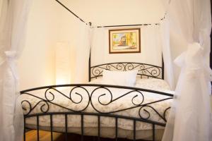 um quarto com uma cama de ferro preto e cortinas brancas em Historic 1869 Brownstone 15 min to NYC downtown em Jersey City