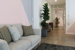 a living room with a gray couch and a plant at Airee Premier Residence in Bangkok