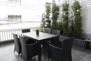 een tafel en stoelen op een balkon met planten bij Airee Premier Residence in Bangkok