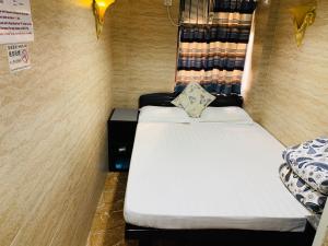 a small room with two beds and a window at Sleep Inn in Hong Kong