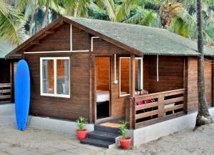 a small house with a surfboard next to it at Silent Beach Resort in Mandrem