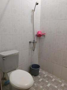 La salle de bains est pourvue de toilettes et d'une douche avec un seau. dans l'établissement Ndalem Cemara Homestay, à Yogyakarta