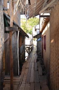 eine Gasse zwischen zwei Gebäuden in einem Dorf in der Unterkunft Coron Backpacker Guesthouse in Coron
