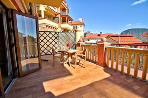 patio con mesa y sillas en el balcón en Villa Balgatura Concept Hotel & Apartaments, en Hurzuf