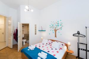 - une chambre avec un lit et un arbre sur le mur dans l'établissement Studio 4U Apartment, à Budapest