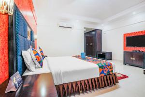 een slaapkamer met een bed en een flatscreen-tv bij FabHotel Royal Mirage With Pool & GYM, Candolim Beach in Candolim