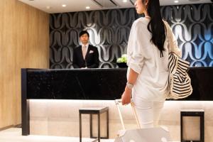 the b ochanomizu في طوكيو: امرأة بيضاء تحمل حقيبة تسوق