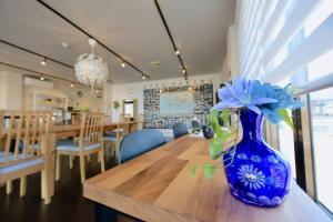 a blue vase with flowers sitting on a table at Ise Guest House Sora in Ise